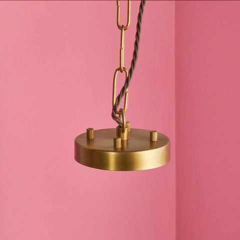 Pooky Athena Chandelier pendant light with brass frame and twisted cord against pink background