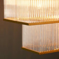Close-up view of the Pooky Odin Chandelier pendant light featuring handcrafted glass rods and a double-tiered brass frame with warm ambient lighting.