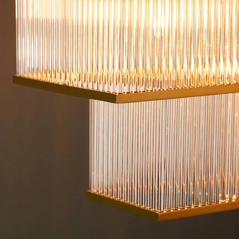 Close-up view of the Pooky Odin Chandelier pendant light featuring handcrafted glass rods and a double-tiered brass frame with warm ambient lighting.