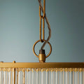 Close-up of golden brass frame and hanging chain of the Odin Chandelier pendant light with handcrafted glass rods