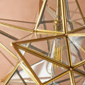 Close-up of Pooky Stella Star Pendant light in clear glass with brass finish and visible filament bulb