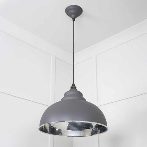Brampton Grey Pendant Light with domed grey steel exterior and polished nickel hammered interior hanging in minimalist white room