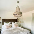 Large Luna Wooden Beaded Pendant Light hanging in a stylish bedroom with neutral tones and soft decor