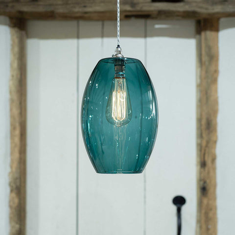 Camber large teal glass shade pendant light with vintage bulb and adjustable hanging cord in modern interior setting