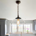 Hythe large clear glass shade pendant light with exposed bulb hanging in modern kitchen interior