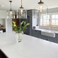 Hythe Large Clear Glass Shade pendant lights hanging above kitchen island with modern white countertop and grey cabinetry