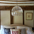 Soho Extra Large ribbed hand blown glass globe pendant light hanging above a bed in a rustic bedroom