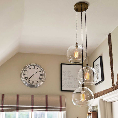 Soho large clear glass shade cluster pendant light with three hand-blown glass globes hanging from adjustable cords in a modern interior setting
