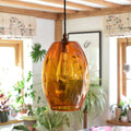 Camber large amber glass shade pendant light with vintage bulb in cozy living space