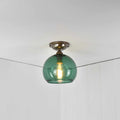 Soho small flush ceiling light with teal glass shade and vintage bulb in white room ceiling corner