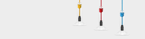 Contemporary small clear glass pendant lights with colorful monkey fist knot cords in yellow, red, and blue designs.