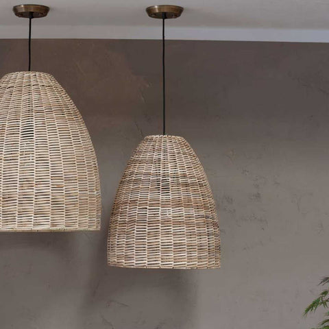 Nkuku Noko Wicker medium conical pendant light with hand-woven natural wicker shade hanging against a textured gray wall