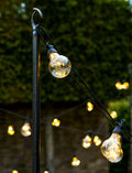Steel festoon poles for outdoor lighting in a garden setting