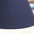 Black fabric lampshade of Whitwell Wooden Table Lamp on rustic wooden surface