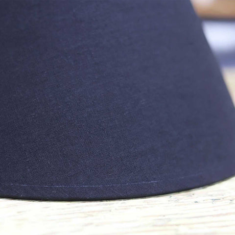 Black fabric lampshade of Whitwell Wooden Table Lamp on rustic wooden surface