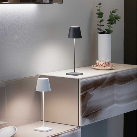 Zafferano Poldina Pro rechargeable modern white and black table lamps on marble shelf with plant and teacup decor