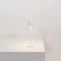 Zafferano Poldina Micro rechargeable white LED table lamp with touch brightness control on a white surface