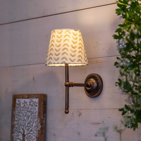 Finberry fabric shade Lupin wall light with patterned shade and bronze finish mounted on wooden wall.