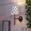 Finberry fabric shade Lupin wall light with patterned shade and bronze fitting on wooden wall