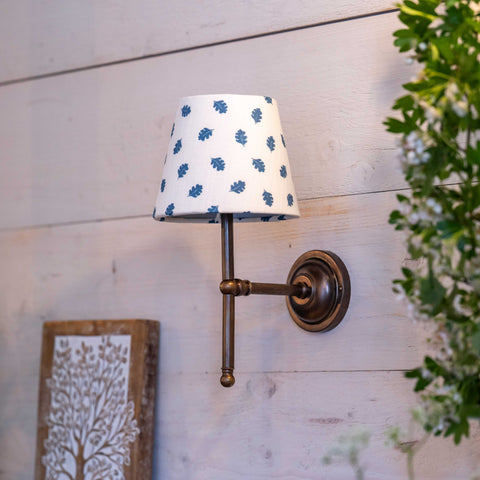 Finberry fabric shade Lupin wall light with blue leaf pattern and bronze finish mounted on wooden wall