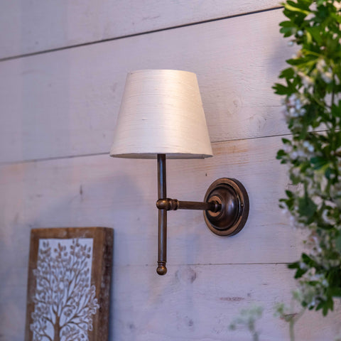 Finberry fabric shade Lupin wall light with cream shade and bronze finish mounted on wooden wall