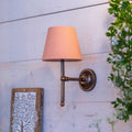 Finberry fabric shade Lupin wall light with pink fabric shade and bronze finish mounted on light wood wall
