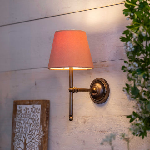 Finberry fabric shade Lupin wall light with orange fabric shade and brass fitting mounted on wooden wall with ambient lighting