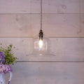 Bodium Medium Clear bell-shaped glass pendant light hanging with exposed bulb and rustic wood background