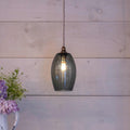 Camber Small Smoked Glass Shade pendant light hanging with exposed bulb and wooden wall background