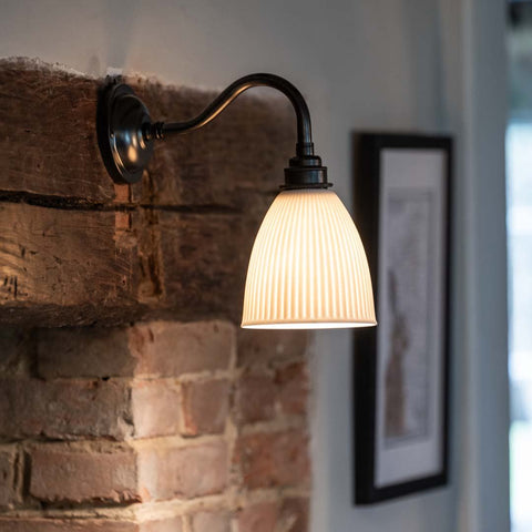 Hartlip Ribbed Ceramic Shade Wall Light mounted on a fireplace