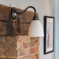 Hartlip Ribbed Ceramic Shade Wall Light mounted on a fireplace