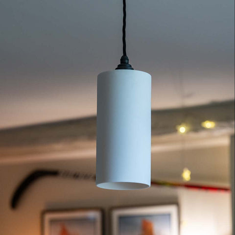 Stockwell Large Ceramic Shade Pendant Light with smooth cylindrical ceramic shade hanging over dining table in modern interior