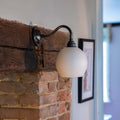 Stanford Ceramic Shade Wall Light mounted on a fireplace with a swan neck fitting
