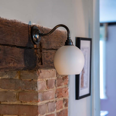 Stanford Ceramic Shade Wall Light mounted on a fireplace with a swan neck fitting