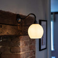 Stanford Ceramic Shade Wall Light mounted on a fireplace with a swan neck fitting