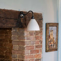 Langton Ceramic Shade Wall Light on a fireplace with a swan neck