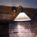 Coolie Ceramic Shade Wall Light mounted on a brick fireplace
