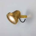 Thames Outdoor Spot Light in raw brass finish mounted on wall with adjustable swivel for outdoor use.