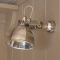 Metallic Foxton Adjustable Spotlight wall light with industrial design mounted on beige wall