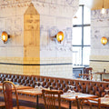 Chulainn Dish Wall Light with vintage brass dish and walnut arm mounted in stylish restaurant interior