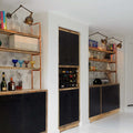 Dale Adjustable Wall Light mounted above shelves illuminating books and decor in a modern room