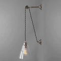 Kairi Pulley Wall Light with adjustable cable, clear glass shade, and industrial silver finish on gray background