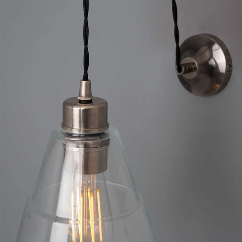 Kairi Pulley Wall Light with clear glass shade and adjustable pulley cable in silver finish mounted on grey wall