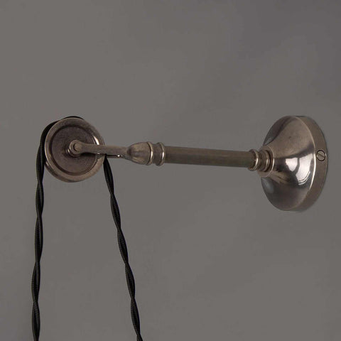 Kairi Pulley Wall Light in silver with industrial adjustable arm and twisted black cable against gray background