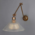 Rebell Prismatic Adjustable Wall Light with antique brass finish and prismatic glass shade mounted on adjustable arm