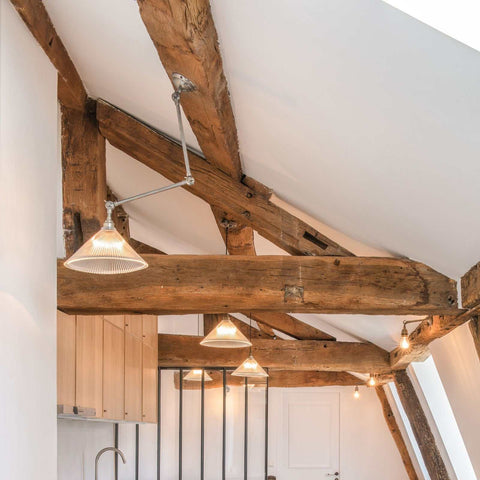 Rebell Prismatic Adjustable Wall Light with prismatic glass shade mounted on rustic wooden beams in modern kitchen interior