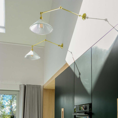 Rebell Prismatic Adjustable Wall Light with prismatic glass shade and brass finish mounted on kitchen wall