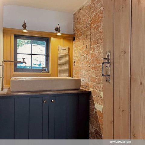 Kent Adjustable Wall Light mounted above bathroom window illuminating rustic and modern decor