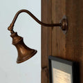 Kent Adjustable Wall Light in antique brass finish mounted on wooden wall with adjustable arm and classic spotlight design