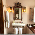 Redford Wall Lantern antique brass wall light installed in elegant bathroom setting with mirror and towels